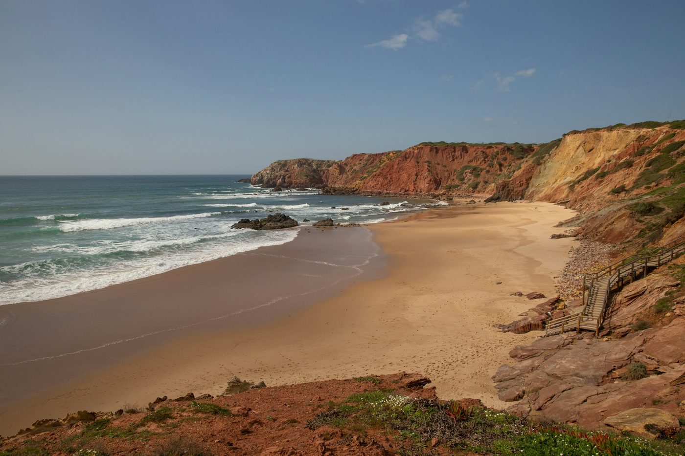 A wide sandy beach and calm water at the south-western tip